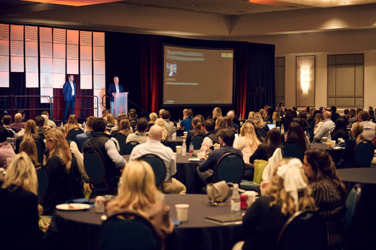Conference audience seated at round tables during a corporate event in Orlando