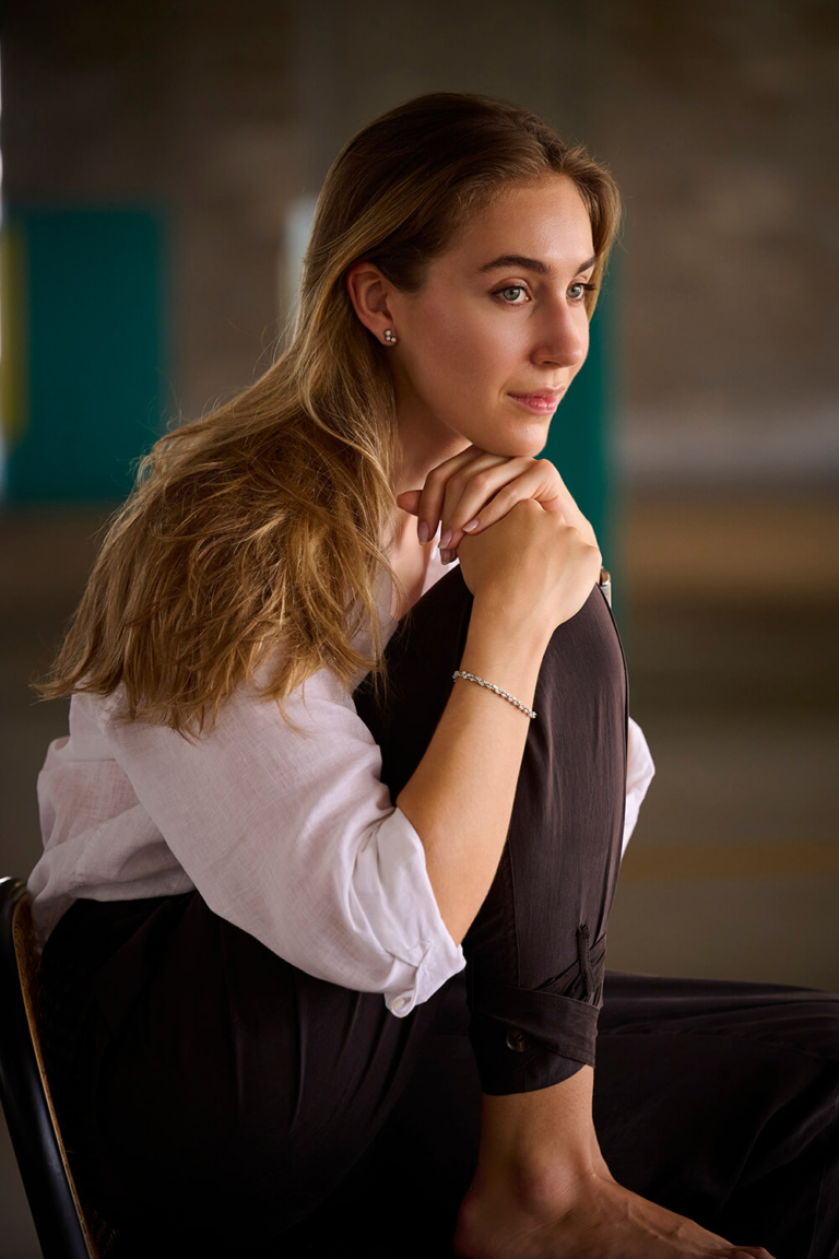 LinkedIn headshot close-up of a woman resting her chin on her hand
