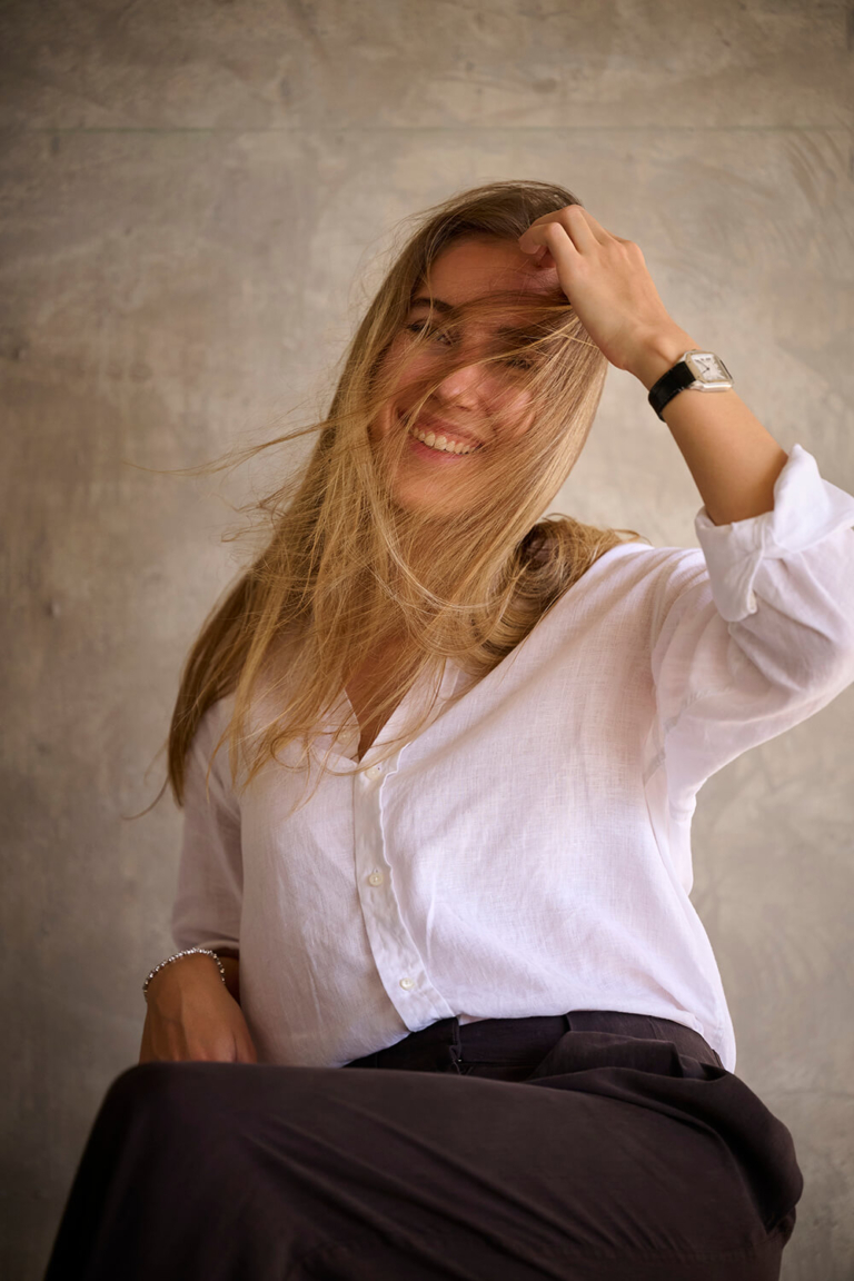Candid personal branding portrait of a woman laughing with her hair in motion