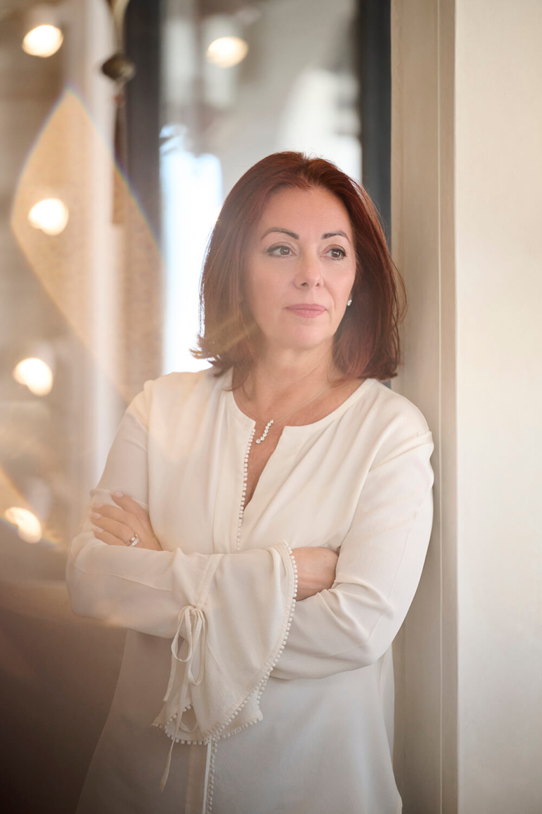 Professional portrait of a business owner leaning against a wall at work in Palm Beach